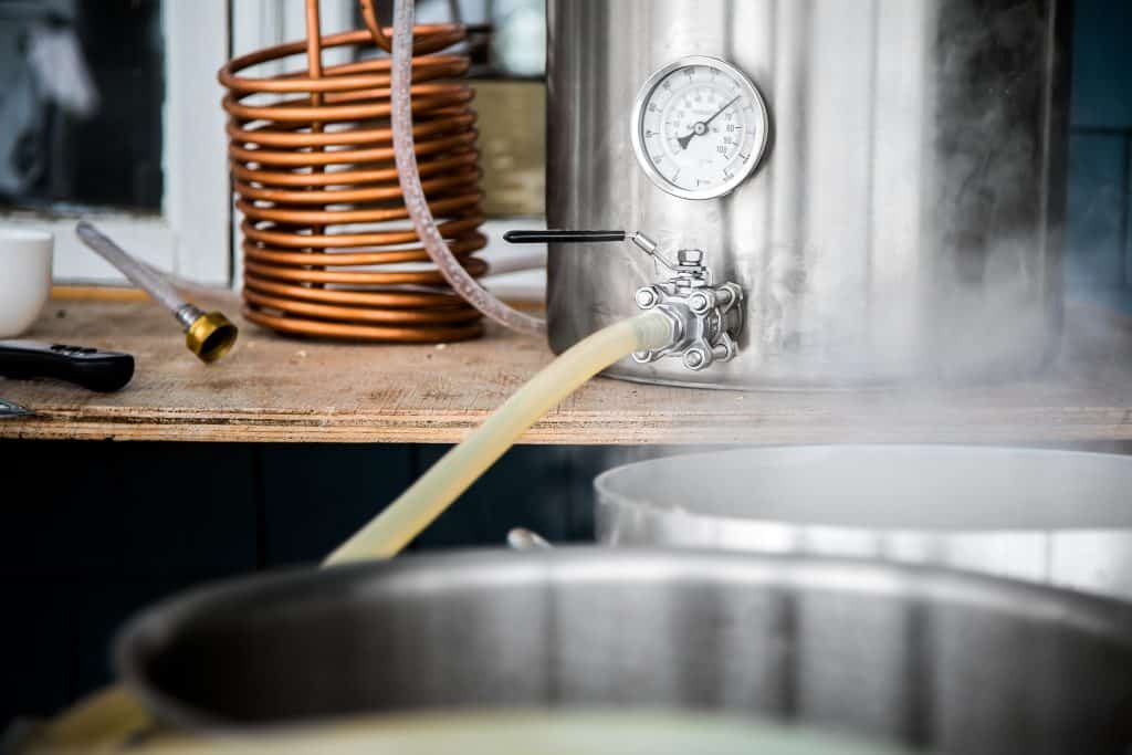 Home Brewing Kit and Pouring Craft Beer Wort into the Boil Kettl